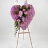 Heart-shaped pink floral arrangement on a wooden easel