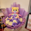 Purple and cream rose bouquet with a teddy bear topper