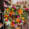 Colorful floral wreath with lilies and mixed blooms on a stand