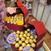 Heart-shaped gift boxes filled with chocolates and ribbon flowers