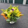 Yellow and orange mixed flower arrangement in a clear vase