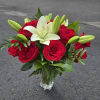Red roses and white lilies in a clear glass vase