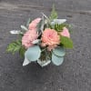 Pink chrysanthemum bouquet in a clear square vase with silver foliage