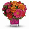 Bouquet of orange roses and pink daisies in a pink glass vase