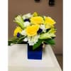 Yellow roses and white lilies in a blue glass vase