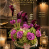 Velvety plum calla lilies and vivid purple roses anchor this elegant flower