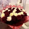 A large, rounded bouquet of tightly packed red and white roses-deep burgundy