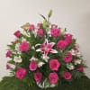 Pink roses and white lilies arranged in a white basket