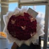 Large bouquet of deep red roses with a gold crown and butterfly decorations
