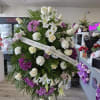 Large standing floral spray with white roses, lilies, and purple daisies