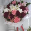 Bouquet of pink, burgundy, and white flowers wrapped in white paper