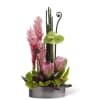 Pink tropical flowers in a low gray container with bamboo accents