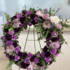 Purple, lavender and white funeral wreath of chrysanthemums, carnations and roses with
