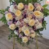 Heart-shaped floral arrangement with cream and lavender roses on a gold stand
