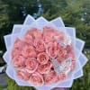 Bouquet of pink roses wrapped in white paper with butterfly decorations