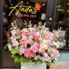 Large pink and lavender mixed flower arrangement in a white basket