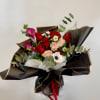 Bouquet of red and pink roses with purple calla lilies in black wrap