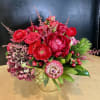 Red floral arrangement in a clear glass vase with pink accents