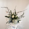 Bouquet of white roses, blue hydrangeas, and white tulips with branching stems