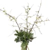 Tall branch arrangement with white blossoms in a glass vase