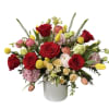 Bouquet of red roses and mixed blooms in a white vase