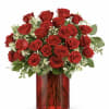 Red roses arranged in a red glass vase