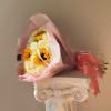 Bouquet of white roses and yellow sunflowers wrapped in pink paper