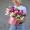 Woman holding a pink box of pink and white flowers