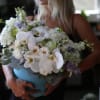 Woman holding a large bouquet of white and lavender flowers