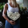 Woman holding a heart-shaped box of white roses