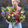 Large bouquet of red, purple, and green flowers with pinecones
