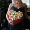 Woman holding a heart-shaped box of peach and white roses