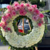 Large pink and white floral wreath on a wooden easel
