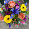 Colorful bouquet with peach roses, yellow gerbera daisies, and blue irises