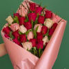 A lush cluster of red, blush, and white roses creates an immediately