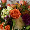 Close-up bouquet with orange roses and purple flowers