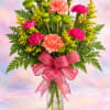 Pink and peach carnations with yellow filler in a glass vase and ribbon