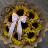 Bouquet of sunflowers with a pink ribbon and brown paper wrap