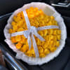 Bouquet of yellow roses wrapped in white paper with a ribbon
