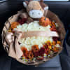 Bouquet of white roses and autumn flowers with a plush cow and pumpkin