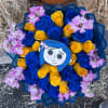 Blue and yellow rose bouquet with pink flowers and a cartoon face topper