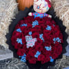 Bouquet of red roses with blue filler flowers and a plush doll topper