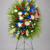 Standing floral wreath with red, white, and blue flowers and an American flag