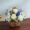 Basket of white and blue flowers on a table