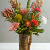 Tropical bouquet in a glass vase with pink and orange blooms