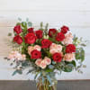 Bouquet of red and blush roses in a clear glass vase