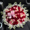 Large bouquet of red, pink, and white roses with a pink bow