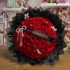 Large bouquet of red roses wrapped in black paper with a birthday ribbon