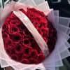 Bouquet of red roses wrapped in pink paper with a satin ribbon