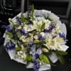 Bouquet of white lilies, blue flowers, and pale hydrangeas